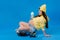 a pregnant girl in yellow clothes with a glass of juice sits on a skateboard on a blue background