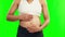 Pregnant, hands on stomach and a woman on a green screen with care, hope and love. Closeup of female person touch or rub