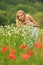 Pregnant happy woman in a flowering poppy field outdoors