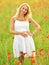 Pregnant happy woman in a flowering poppy field outdoors