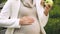 Pregnant lady eating fresh green apple and tenderly stroking belly, waiting baby