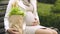 Pregnant lady with shopping bag sitting on bench to have rest, single mother