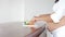 Pregnant Latin American woman standing at wood counter in kitchen cutting vegetables