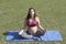 Pregnant latin woman doing yoga in a park
