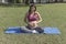 Pregnant latin woman doing yoga in a park