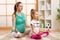 Pregnant mother and child do yoga, relax in lotus