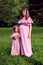 Pregnant mother and daughter in identical lilac dresses posing i