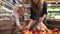 Pregnant mother and her daughter buying fruits at shopping center