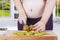 Pregnant mother slicing kiwi fruits in kitchen