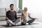 Pregnant muslim couple practicing prenatal yoga at home, meditating together