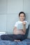 Pregnant reading a book. Pregnant woman reading a book on the sofa in the living room