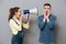 Pregnant screaming woman holding loudspeaker standing near man