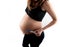 Pregnant skinny slim fit woman holding a positive pregnancy test on her belly tummy abdomen