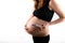 Pregnant skinny slim fit woman holding a positive pregnancy test on her belly tummy abdomen