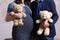 Pregnant wife and husband hold bears in hands