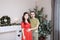 Pregnant wife and husband young family portrait in Christmas interior