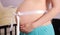 Pregnant woman abdomen with white bow.