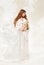 Pregnant woman. Beautiful pregnancy: long curly hair and chiffon