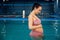 Pregnant woman with big belly swimming in the pool