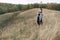 Pregnant woman in black dress and dreadlocks on the background of wild nature