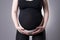 Pregnant woman in black tights with orthopedic support belt, pregnancy bandage