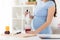 Pregnant woman with blender making smoothie drink