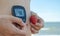Pregnant woman with blood control meter and strawberry taking control of gestational diabetes close up