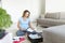 Pregnant woman in blue t-shirt  checklist and preparing stuff for maternity hospital at home. Happy pregnancy packing baby clothes