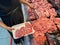 Pregnant woman buying raw pork chops at butcher shop