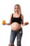 Pregnant woman choosing between a hamburger and pepper. Close up. White background