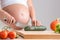 Pregnant woman chopping fresh vegetables