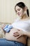 Pregnant woman on the couch with blue booties