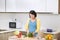 Pregnant woman cutting broccoli for fresh green salad, female prepares tasty organic dinner at home