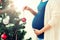 Pregnant woman decorating christmas tree