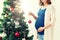 Pregnant woman decorating christmas tree