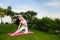 Pregnant woman doing prenatal yoga on nature.