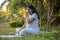 pregnant woman doing yoga breathing exercise Pranayama in park or garden