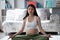 Pregnant woman doing yoga exercising front of sofa hand is lotus symbol in room. Pregnant woman yoga and healthy lifestyle concept