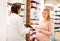 Pregnant woman and druggist at pharmacy