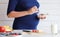 Pregnant woman eat a bowl of yogurt and fruits