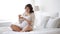 Pregnant woman eating croissant in bed at home 4