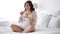 Pregnant woman eating croissant in bed at home 5