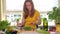 Pregnant woman eating small tomato vegetables sitting near table in kitchen