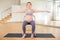 Pregnant woman is engaged in yoga. Exercise on chair with arms spread apart