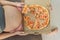A pregnant woman enjoys a slice of pizza, savoring a moment of indulgence while satisfying her craving for a delightful