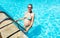Pregnant woman enter swimming pool with big belly