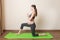 Pregnant woman exercising on green mat in room. Pregnancy Yoga and Fitness concept at coronavirus time