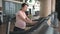 Pregnant woman exercising in the gym indoors walking on a treadmill for a fit and active lifestyle during pregnancy