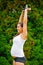 Pregnant Woman Exercising Triceps Extension With Dumbbell In Park