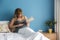 A pregnant woman feels the baby movement in belly while holding a book